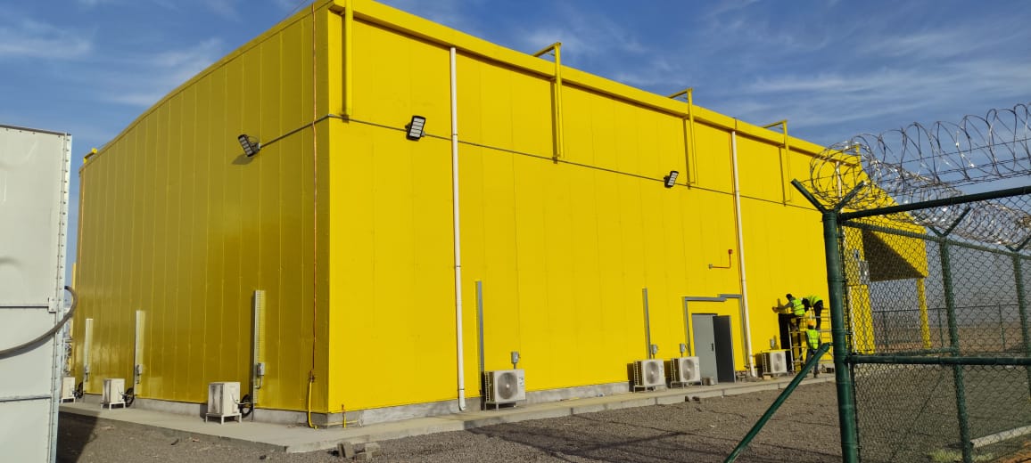 Completed yellow warehouse exterior, Tabarjal Solar Power Plant, Saudi Arabia